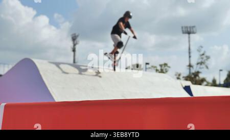 Rollerfahrer in der Mitte der Luft beim Skatepark-Wettbewerb im Freien Stockfoto