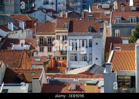 Blick auf traditionelle Gebäude mit orangefarbenen Terrakottadächern und Wäscherei von einem Balkon in Lissabon, Lissabon, Portugal. Stockfoto