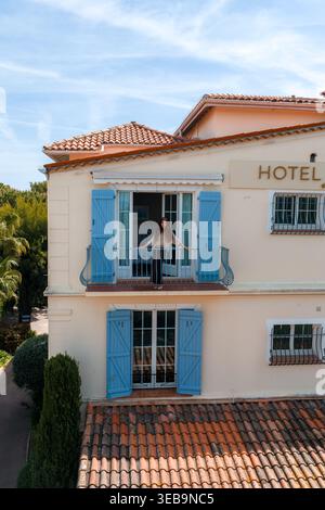 Blick aus der Vogelperspektive auf die Hotelfassade von Antibes mit Terrasse und pastellfarbenen Fensterläden Stockfoto