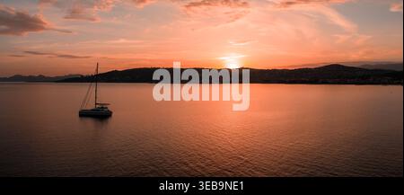Segelboot mit dem Flugzeug bei Sonnenuntergang in der Bucht von Antibes, Frankreich Stockfoto