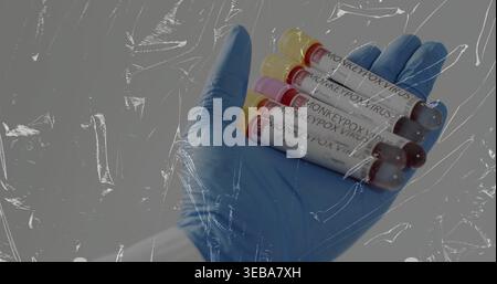Handschuhe in blauem Nitril und weißem Fell mit vier AFFENPOCKENVIRUSRÖHRCHEN in der Klinik Stockfoto