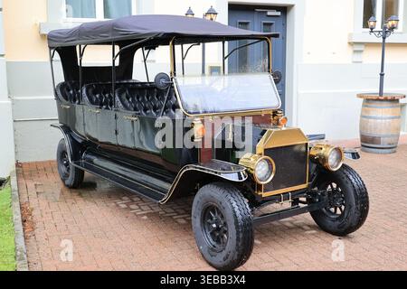 Nachbildungen der Oldtimer stehen vor dem Pub Green Harp in Meiringen, Schweiz Stockfoto