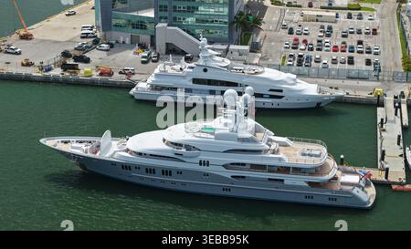 Riviera Beach, Vereinigte Staaten - 15. April 2026: Blick aus der Vogelperspektive auf luxuriöse Superyachten am Yachthafen mit einem modernen Gebäude und Parkplatz im bac Stockfoto