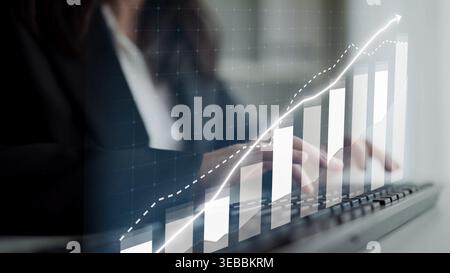 Geschäftsleute nutzen die Datenanalyse über eine Tastatur, während ein Diagramm für das Wachstum des Aufstiegs das Bild überlagert und damit den finanziellen Erfolg und symbolisiert Stockfoto