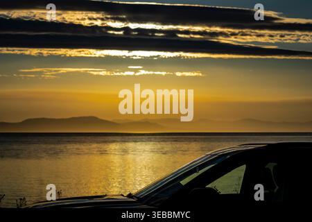 Bewölkter Morgen über dem Festland der Rocky Mountains in British Columbia, von Comox auf Vancouver Island aus gesehen. Stockfoto