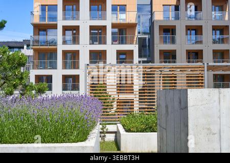 Modernes mehrstöckiges Wohnapartmentgebäude mit zeitgenössischem architektonischem Design und klaren geometrischen Linien, weißen und grauen Fassaden Stockfoto