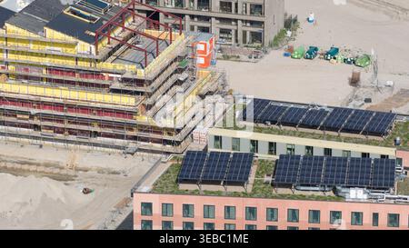 Amsterdam, Niederlande - 14. April 2026: Luftaufnahme der Baustelle Sluisbuurt mit Gebäuden mit Gerüsten, gelber Isolierung und Solarzellen Stockfoto