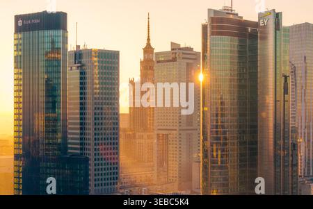 Warschau, Polen - 07. März 2026: Aus der Vogelperspektive auf den Palast der Kultur und Wissenschaft, umgeben von modernen Glashochhäusern bei einem goldenen Sonnenuntergang. Stockfoto