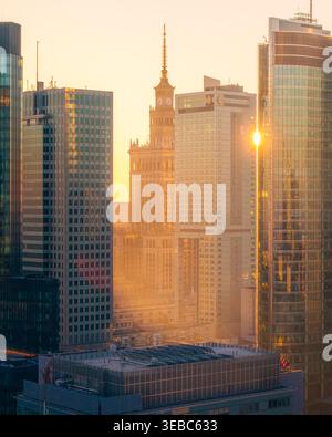Warschau, Polen - 07. März 2026: Aus der Vogelperspektive auf den Palast der Kultur und Wissenschaft, umgeben von modernen Glashochhäusern bei einem goldenen Sonnenuntergang. Stockfoto