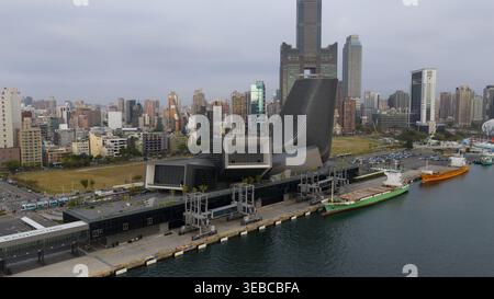 Yicheng Village, Taiwan - 25. Februar 2026: Aus der Vogelperspektive auf den Hafen von Kaohsiung mit seiner futuristischen Architektur, angedockten Frachtschiffen und Th Stockfoto