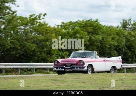 Varadero, Kuba - 2. September 2023: Dodge Custom 1957 Cabriolet aus den 1950er Jahren, zweifarbiges rosa-weißes Oldtimer in Kuba, Bewegungsunschärfeeffekt Stockfoto