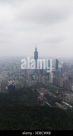 Xicun Village, Taiwan - 20. Februar 2026: Aus der Vogelperspektive des Wolkenkratzers Taipei 101, der sich über der dichten Skyline erhebt, und Wohngebäude unter A Stockfoto