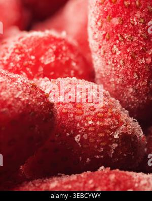 Gefrorene Erdbeeren Makro mit Eiskristallen, frischer roter Frucht Textur Hintergrund mit Frostdetail Stockfoto