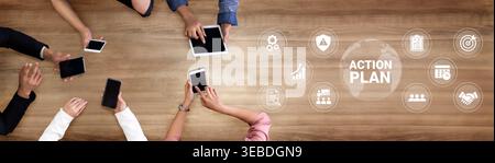 Luftaufnahme einer vielfältigen Gruppe von Personen, die gemeinsam an einem digitalen Aktionsplan arbeiten und Tablets und Smartphones auf einem Holztisch nutzen Stockfoto