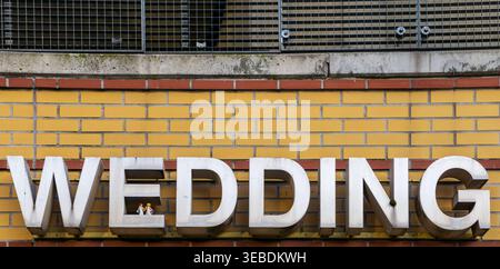 Nahaufnahme des Schriftstücks „Wedding“ mit kleinen dekorativen Hochzeitsfiguren am S-Bahnhof Wedding in Berlin. Stockfoto