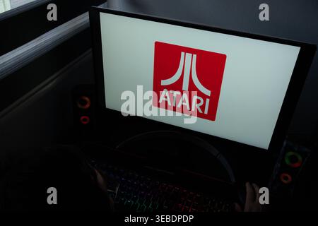 Das Atari-Logo auf rotem Hintergrund wird auf einem Computerbildschirm in einem dunklen Raum angezeigt Stockfoto