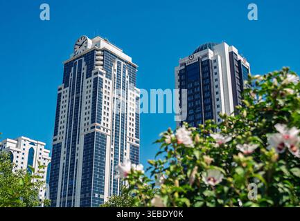 Grosny, Russland - 30. Juli 2021: Stadttürme von Grosny mit modernen Wolkenkratzern und üppig grünen Parkbäumen Stockfoto