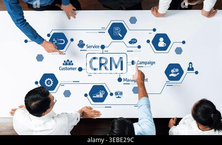 Eine Top-down-Ansicht eines professionellen Teams, das an einer Strategie für das Kundenbeziehungsmanagement arbeitet, mit einem interaktiven Diagramm, das veranschaulicht Stockfoto