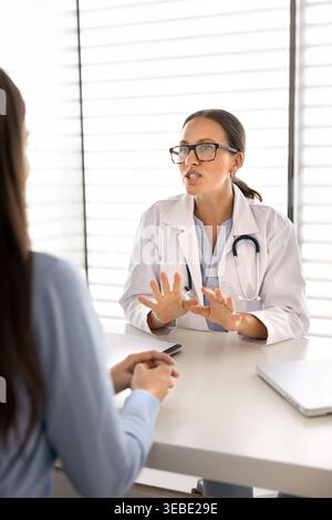 Arzt gibt Gesundheitsempfehlungen und erklärt den Behandlungsplan der Patientin Stockfoto