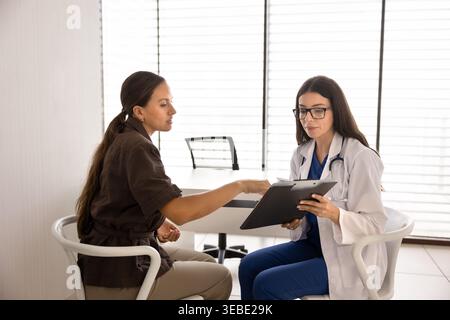Arzt und Patient diskutieren Ergebnisse medizinischer Gesundheitstests in der Klinik Stockfoto