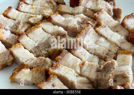Sauber geschnittene Bauchstreifen mit gebratenem Schweinefleisch mit goldenen Kanten für herzhafte Küche und knuspriges Fleisch Stockfoto