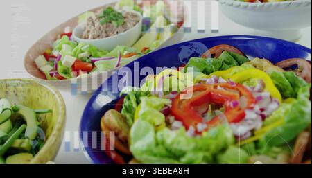 Mit blauer Keramikschale mit farbenfrohem Salat auf weißer Arbeitsplatte, Avocado und Croutons Stockfoto
