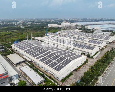 Luftaufnahme von Industriebetrieben mit Solarpaneelen auf Dächern unter bewölktem Himmel in Phuoc, Dong Nai, Vietnam. Stockfoto
