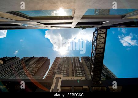 Dramatische Aufnahmen aus niedrigem Winkel mit einem hellen Sonnenaufgang, Wolken, Wolken, Wolken und einer industriellen Metallbrücke. Stockfoto
