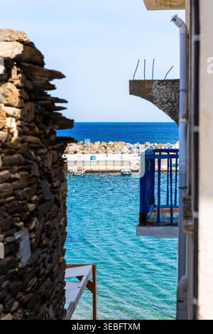 Karavostamo, Griechenland kleines griechisches ägäisches Dorf Straße Wohnhaus Balkon mit Blick auf den ikarischen See Pier Hafen oder Yachthafen mit Fischerbooten Stockfoto