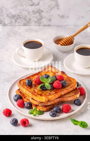 Französischer Toast mit Heidelbeeren, Himbeeren, Ahornsirup, Frühstück am Morgen. Stockfoto