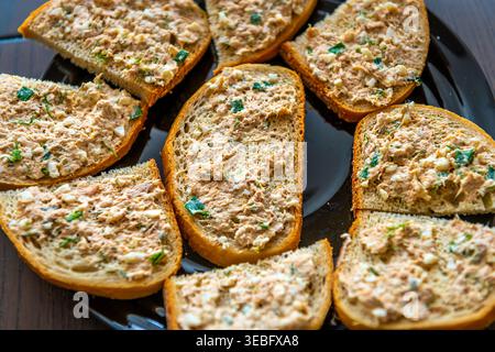 Thunfisch-Salat-Sandwich, viele Sandwiches auf schwarzem Teller in der Küche, hausgemachtes Essen Makronähe Tisch oben flach Blick Stockfoto