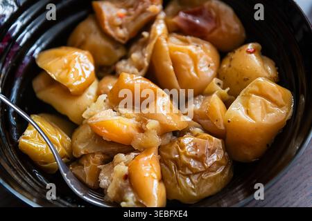 Gebackene Äpfel ganz und in Scheiben geschnittene Stücke auf Küchentischplatte mit Gabel Makroaufnahmemöglichkeit Stockfoto