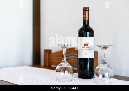 Insel Ikaria, Griechenland - 12. Juni 2023: Agaios eoss griechischer Rotwein mit Glasflasche und zwei Weingläsern zum Trinken in der Longevity Blue Zone Home Stockfoto