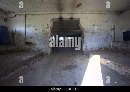 Leere Scheune in einem verlassenen Herrenhaus mit Sonnenstrahl in den Raum, auf dem italienischen Land Stockfoto