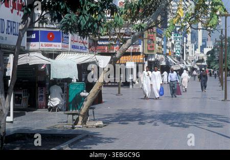 Shopper gehen entlang einer Fußgängerzone im historischen Al Ras Viertel von Deira, Dubai, Vereinigte Arabische Emirate. Stockfoto