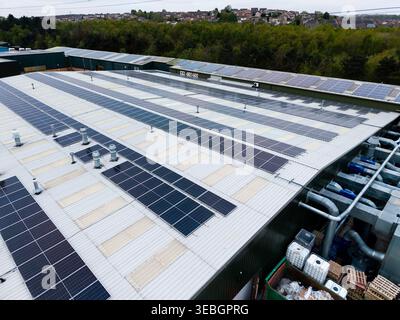 Aus der Luftaufnahme von Solarpaneelen auf dem Dach eines verantwortlichen Geschäftsgebäudes erzeugt saubere Energie für die Fertigung Stockfoto