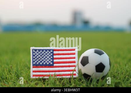 US-Nationalflagge und Fußball auf grünem Stadiongras. Symbolisches Image für internationale Fußballspiele, Teamstolz und Medieninhalte. Stockfoto