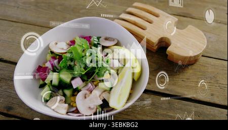 Mit weißer Keramikschale, die Salat auf rustikalem Tisch hält, mit Holzservern und AR-Überzügen Stockfoto