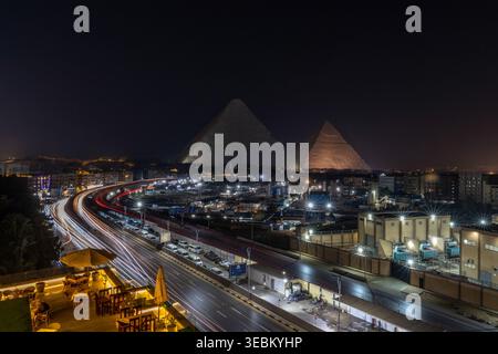 Nächtlicher Blick auf die Stadt Kairo mit den beiden Pyramiden Cheops und Chephren im Hintergrund Stockfoto