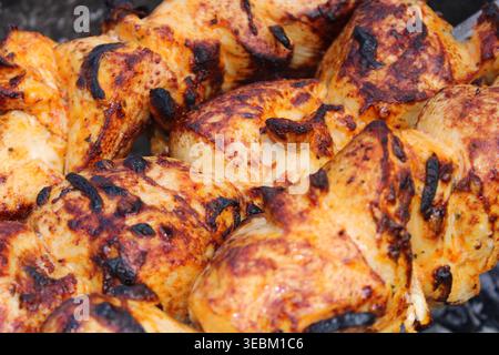Saftige gegrillte Hähnchenspieße schaschig kochen auf Holzkohlegrill im Freien Stockfoto