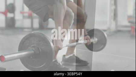 Packende Langhantel, Sportler in dunklen Shorts und niedrigen Schuhen, die Deadlift im Fitnessstudio vorbereiten, Platte im Vordergrund Stockfoto