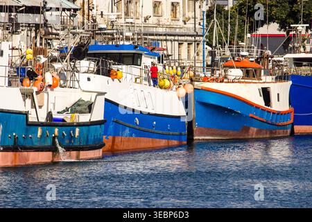 Blaue, rote und weiße Fischerboote legten am Hafen an der V&A Waterfront in Kapstadt, Südafrika, an. Stockfoto