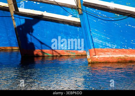 Nahaufnahme der blauen, roten und weißen Bögen von Fischerbooten am Hafen an der V&A Waterfront in Kapstadt Südafrika. Stockfoto