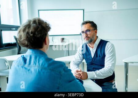 Der Lehrer unterstützt den Lernenden mit Lernschwierigkeiten während des Unterrichts. Stockfoto