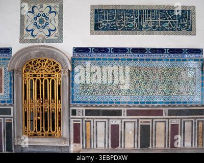 Komplizierte osmanische Fliesen und goldene arabische Kalligraphie zieren die Wände des historischen Topkapi-Palastes und Harems in Istanbul, Türkei, unter weichem Licht Stockfoto