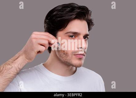 Schöner mann Anwendung feuchtigkeitsspendende Serum auf Gesicht Stockfoto