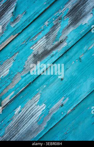 Nahaufnahme von verwittertem blau lackiertem Holz mit abblätternder Farbe und diagonalen Dielen. Abstrakter rustikaler Hintergrund für Vintage-Design und kreative Projekte. Stockfoto
