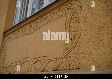 Dekoratives Jugendstil-Fassadenrelief auf einem ockerfarbenen Wohnhaus in Berlin-Steglitz, Muthesiusstraße. Stockfoto