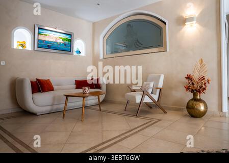 Wohnzimmer mit Sonnenlicht in Antibes mit Bogennischen und weißem Sofa Stockfoto