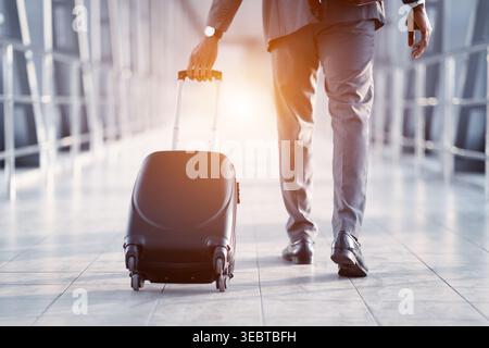 Geschäftsmann mit Koffer, Wandern über Fluggastbrücken Stockfoto